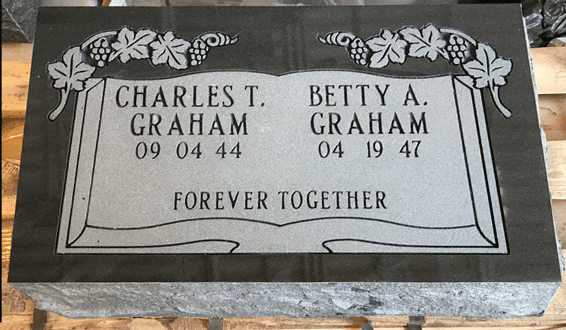 Black granite flat grave marker engraved as an open book with grapevine borders
