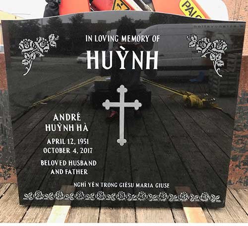 Black granite companion headstone with cross and floral corners