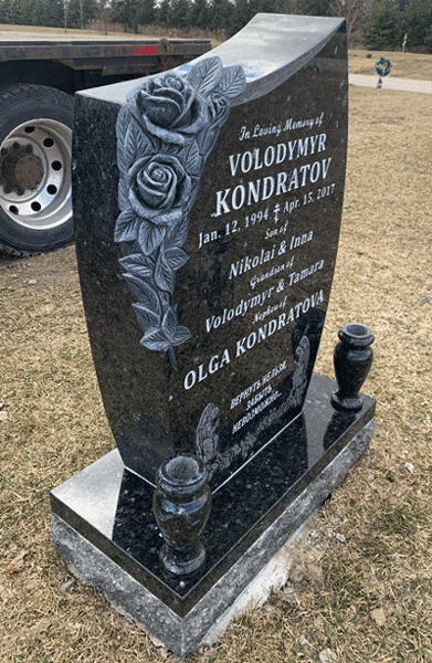 Side view of black granite curved upright headstone