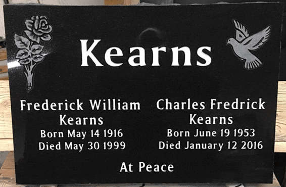 Black granite flat grave marker with a carved rose and a dove