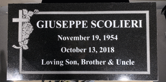 Black granite flat grave marker with an engraved cross entwined with roses and a butterfly