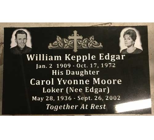 Black granite flat grave marker with two laser-etched portraits and a central cross with floral carving