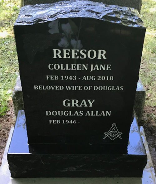 Black granite upright companion headstone with Masonic emblem