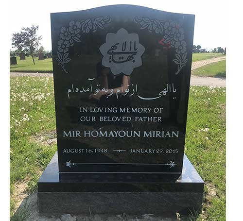 Black granite upright headstone with Arabic script and raised fist emblem