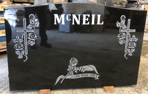 Black granite upright headstone with engraved crosses entwined with roses and a rose banner