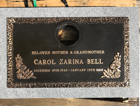 Bronze grave marker on granite with rose border