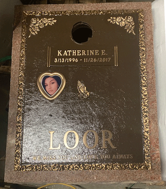 Bronze memorial plaque with cameo portrait and floral border