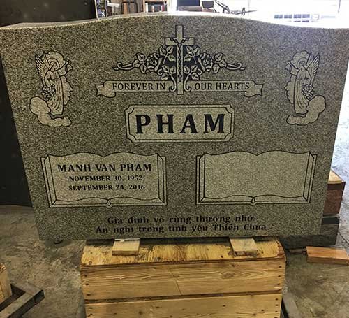 Gray headstone with cross book and angel artwork