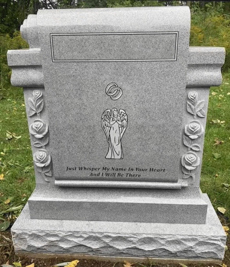 Angel and roses carved in relief on a gray granite upright monument