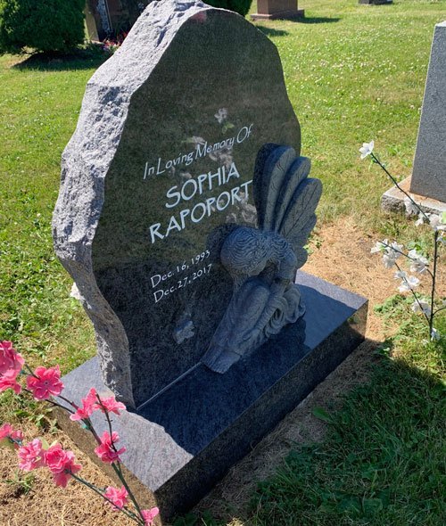 Bahama Blue granite boulder shaped headstone with a carved kneeling angel