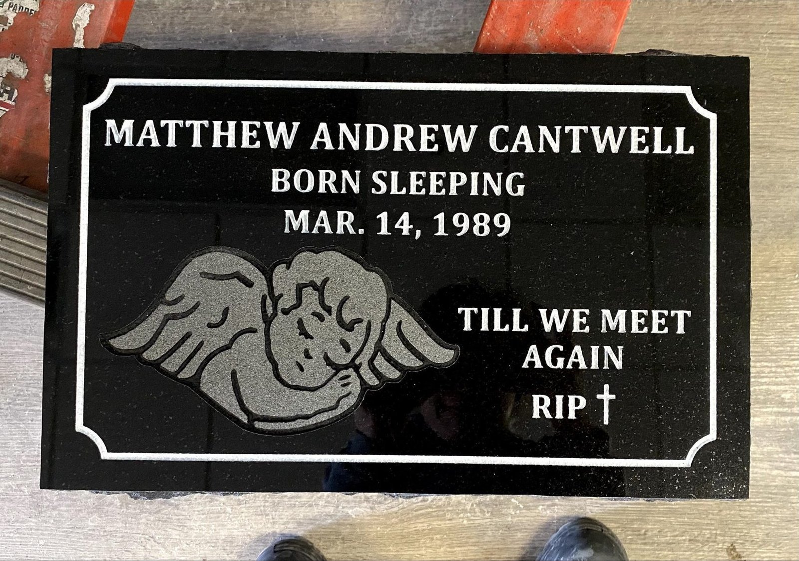 Black flat marker with praying hands engraving