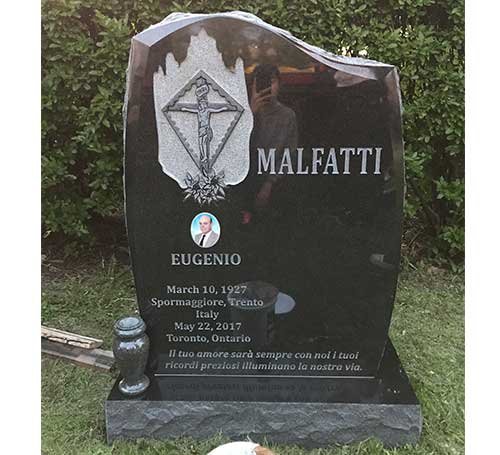 Black granite curved headstone with geometric symbol and rose