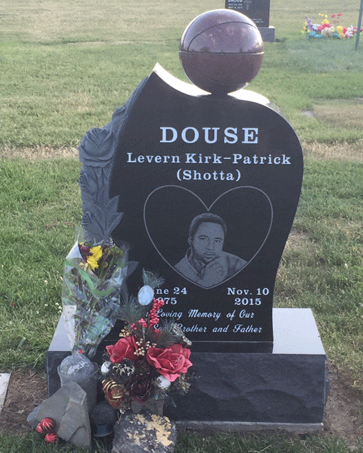 Black granite headstone with a basketball on top and a heart shaped laser etched portrait