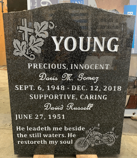 Dark Brits granite upright headstone with cross and ivy and an engraved motorcycle