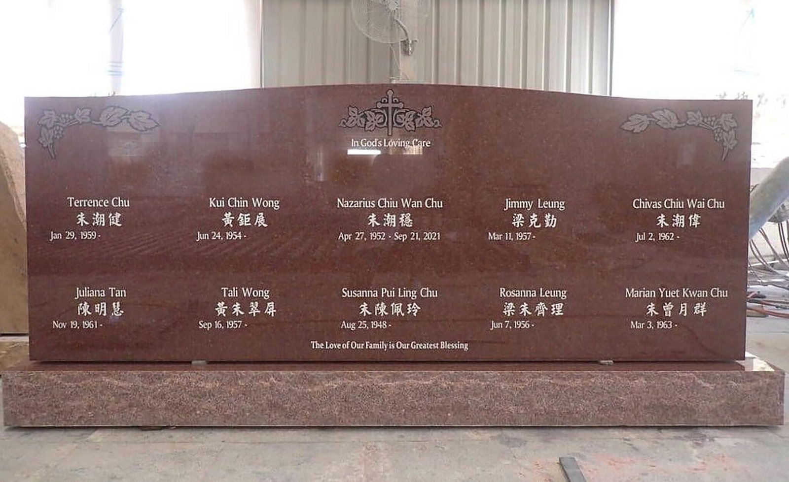 Indian Red granite family monument with ten names in English and Chinese, grape vine corners and a carved cross