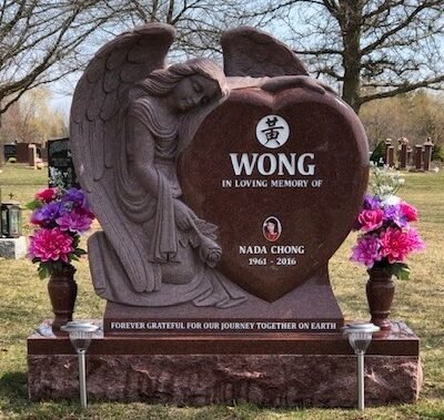 Indian Red granite heart shaped headstone with a carved embracing angel and a Chinese character