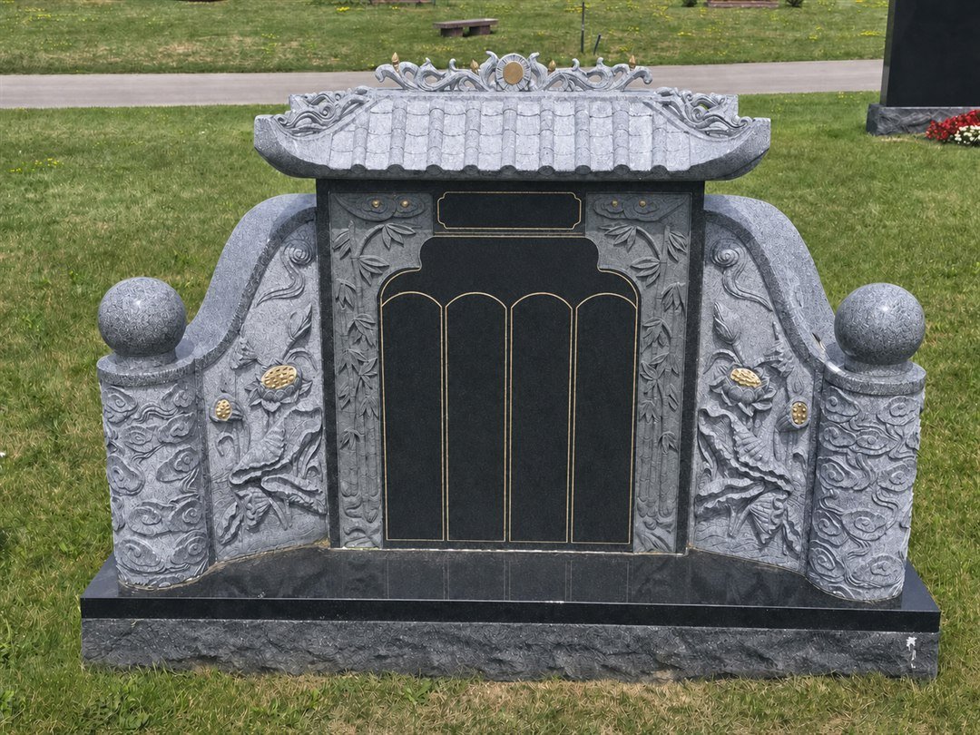 Chinese style granite monument with a tiled roof, an openwork ridge crest and a dark center panel