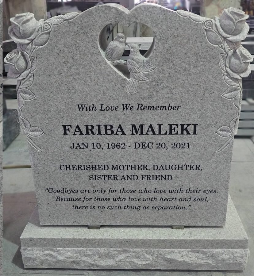 Granite upright memorial with carved rose borders and two doves in a heart shaped window