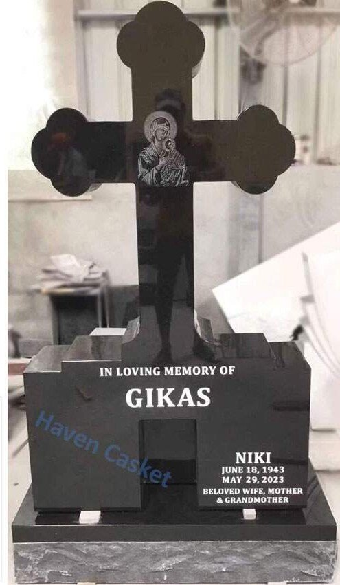 Black granite Orthodox cross monument with a budded cross and an engraved icon, in the Haven workshop