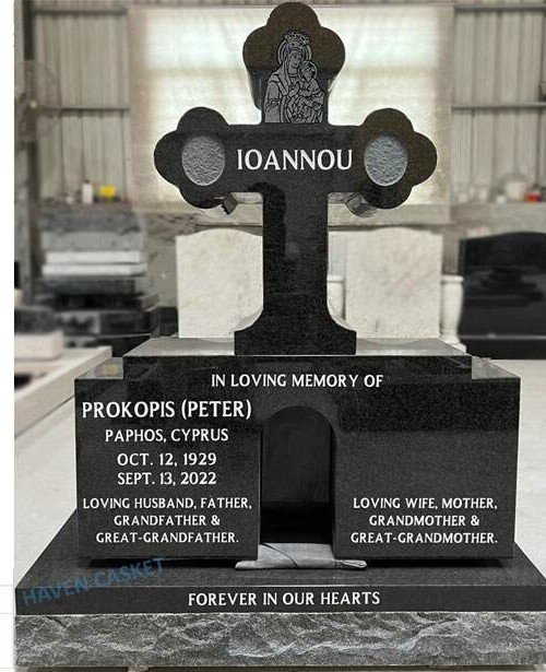 Tall Black granite Orthodox cross monument with an engraved icon and ceramic photo ovals, in the Haven workshop