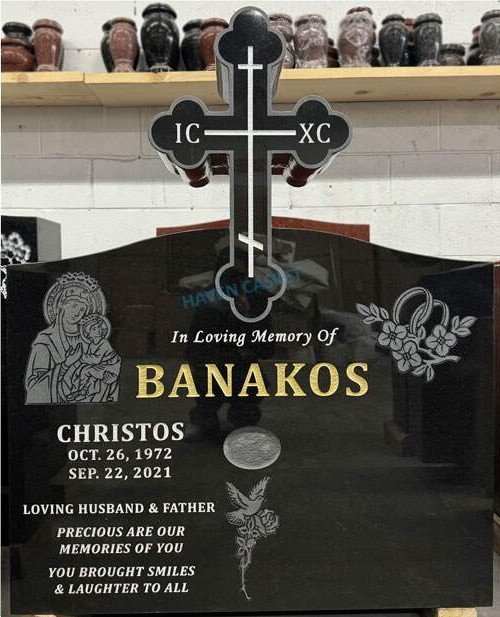 Black granite monument with a three bar Orthodox cross above the tablet, in the Haven workshop