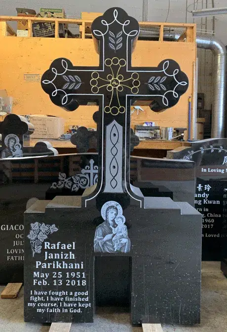 Black granite trefoil cross monument with gold and white scroll engraving, an etched Madonna and Child and a rose