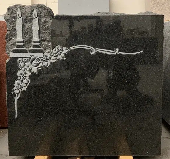 Black granite headstone with etched candles and roses