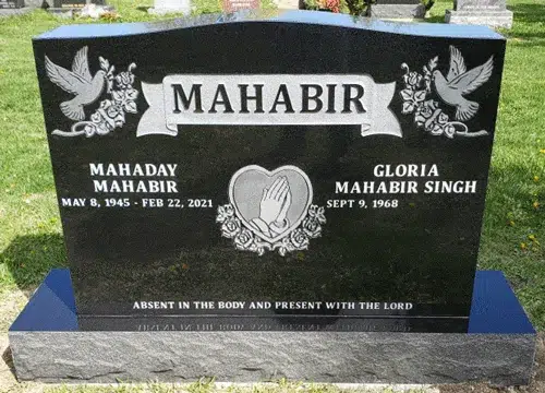 Black granite companion headstone with a dove in each upper corner, a surname ribbon banner and praying hands inside a heart