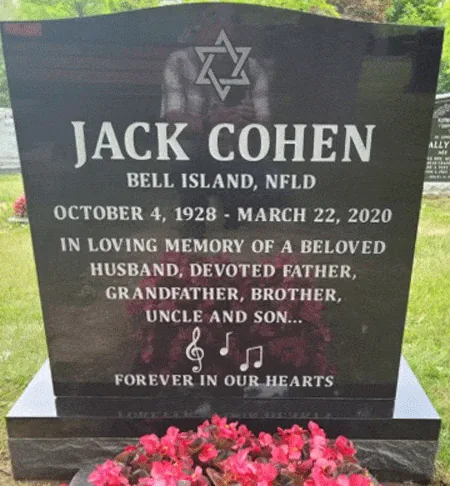 Black granite upright headstone with an etched Star of David, treble clef and music notes, and red flowers at the base