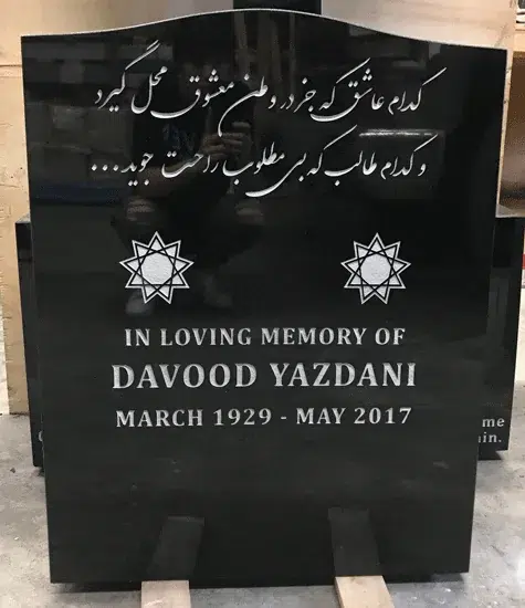 Black granite upright headstone with engraved star emblems and a Persian inscription