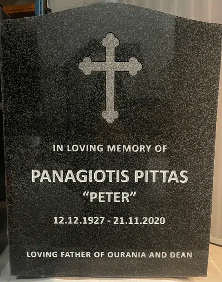 Dark Brits granite serpentine top headstone with a budded trefoil cross