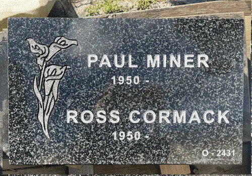 Dark Brits granite flat grave marker with engraved calla lily artwork and two names with dates in block lettering
