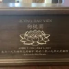 Engraved Wood Urn with Lotus Flower Dark brown wood urn engraved with a lotus flower, a name in Vietnamese and Chinese, dates and a short epitaph