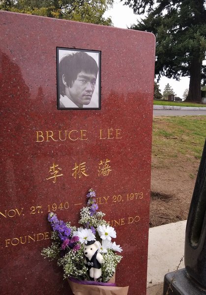 Polished red granite upright headstone with a black and white portrait and gold lettering at Lake View Cemetery, Seattle