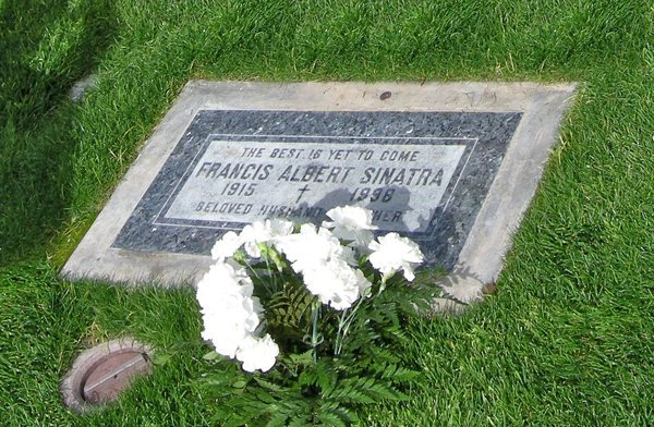 Flat dark grey granite grave marker in a lawn with white carnations, Desert Memorial Park, Cathedral City