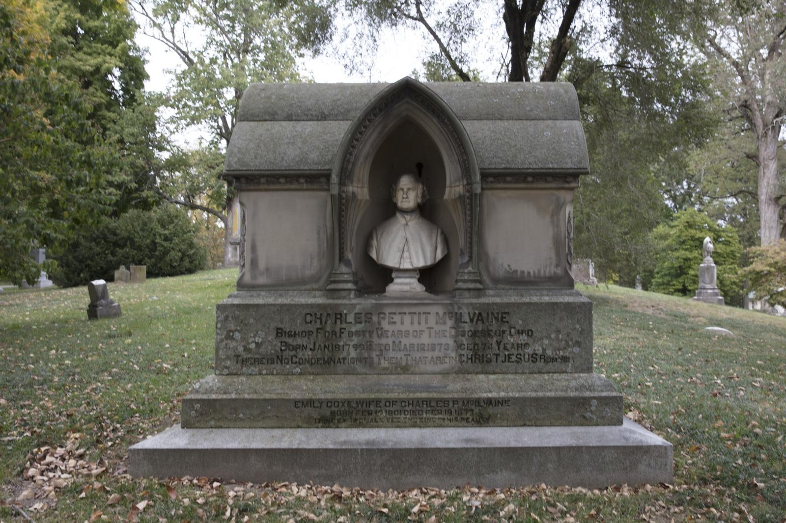 Grey stone monument with a white stone bust in an arched niche over a carved inscription, Spring Grove Cemetery, Cincinnati