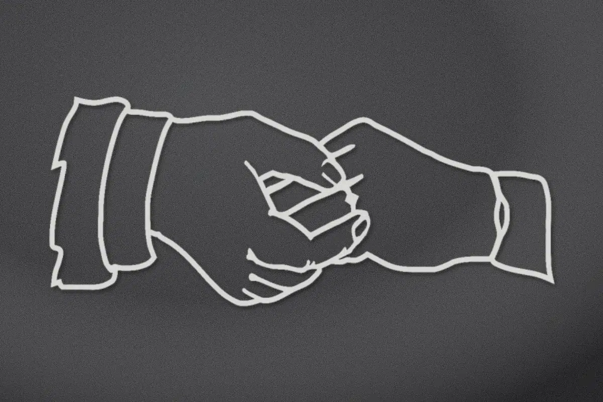 Two clasped hands with different cuffs engraved on black granite