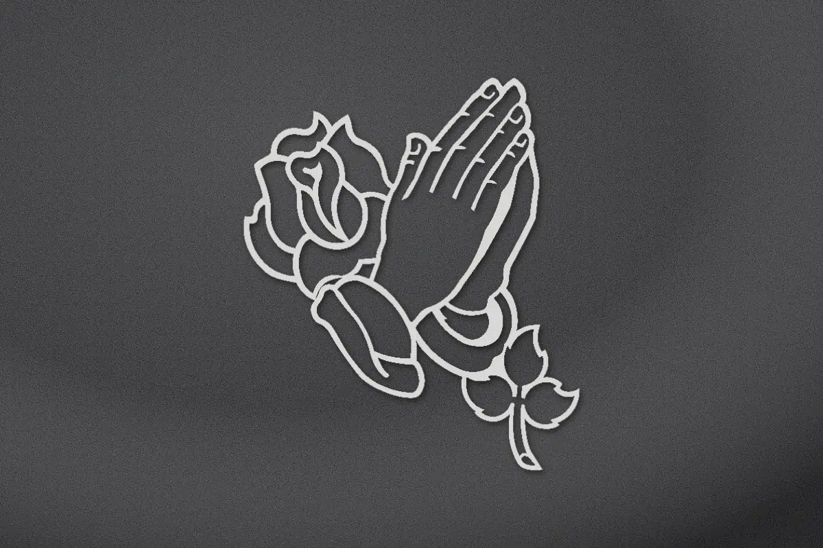 Praying hands with a rose engraved on black granite