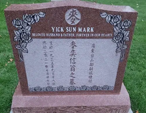Indian Red granite serpentine headstone with etched roses down both sides and a lighter panel of raised Chinese characters