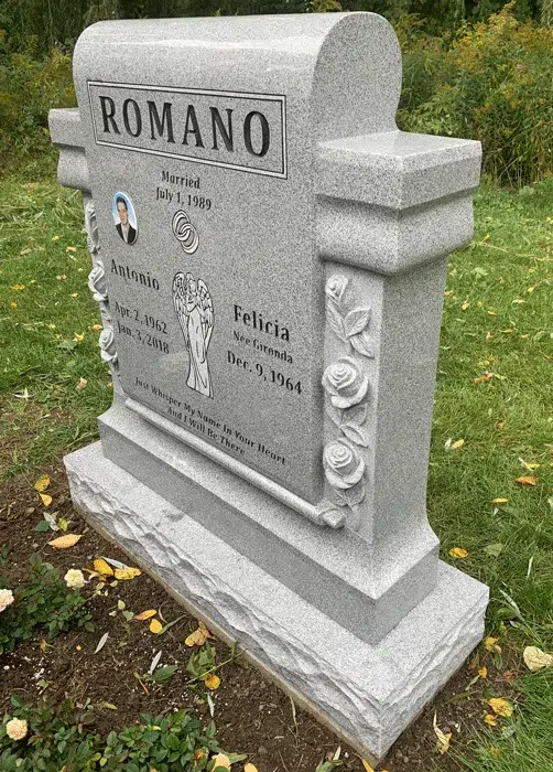 Light gray granite companion headstone with an arched top, carved rose columns, an angel etching and a small portrait