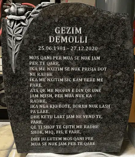Silver Bronze granite upright headstone with a rose carved in relief at the top corner, an engraved name, dates and epitaph